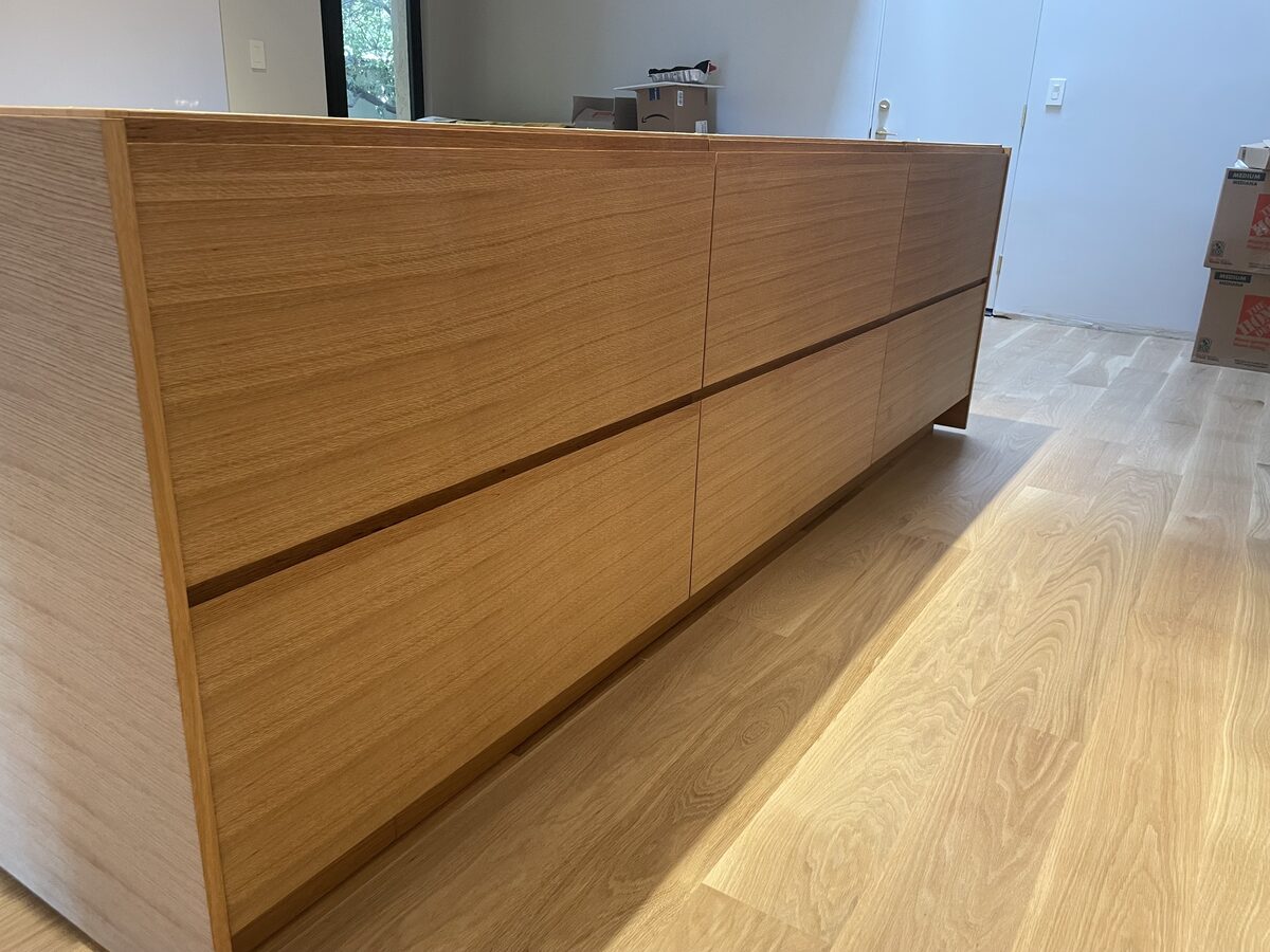 White oak cabinet door with integrated J-pull handle detail