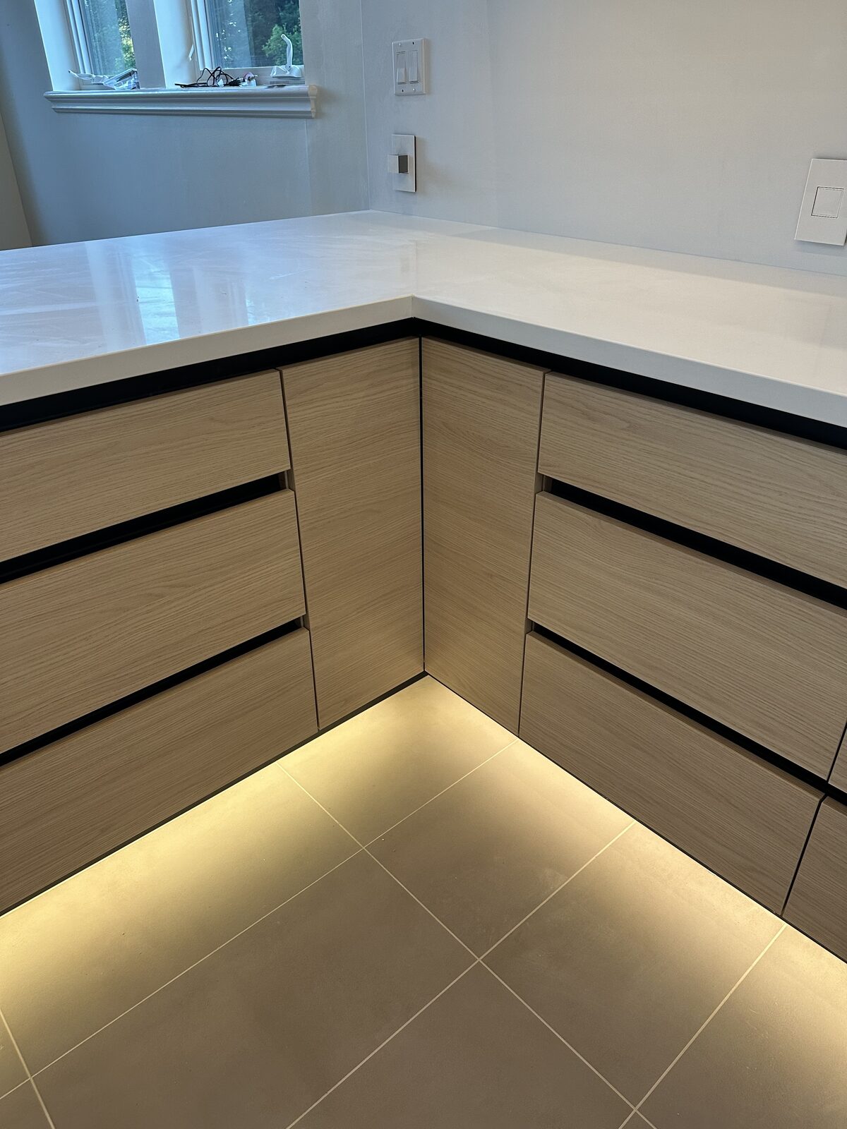 White oak cabinet with finger pull channel detail at base