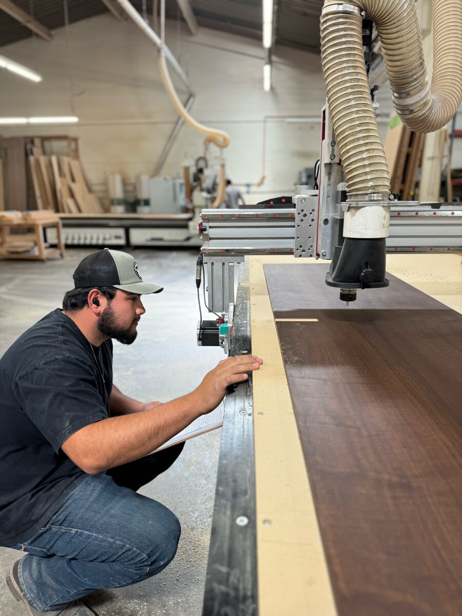 DodiHome team member inspecting walnut at the CNC machine in the Milpitas factory