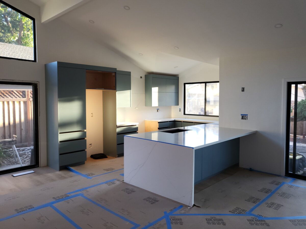 Primary finished-room view of blue-grey kitchen cabinetry and surrounding surfaces