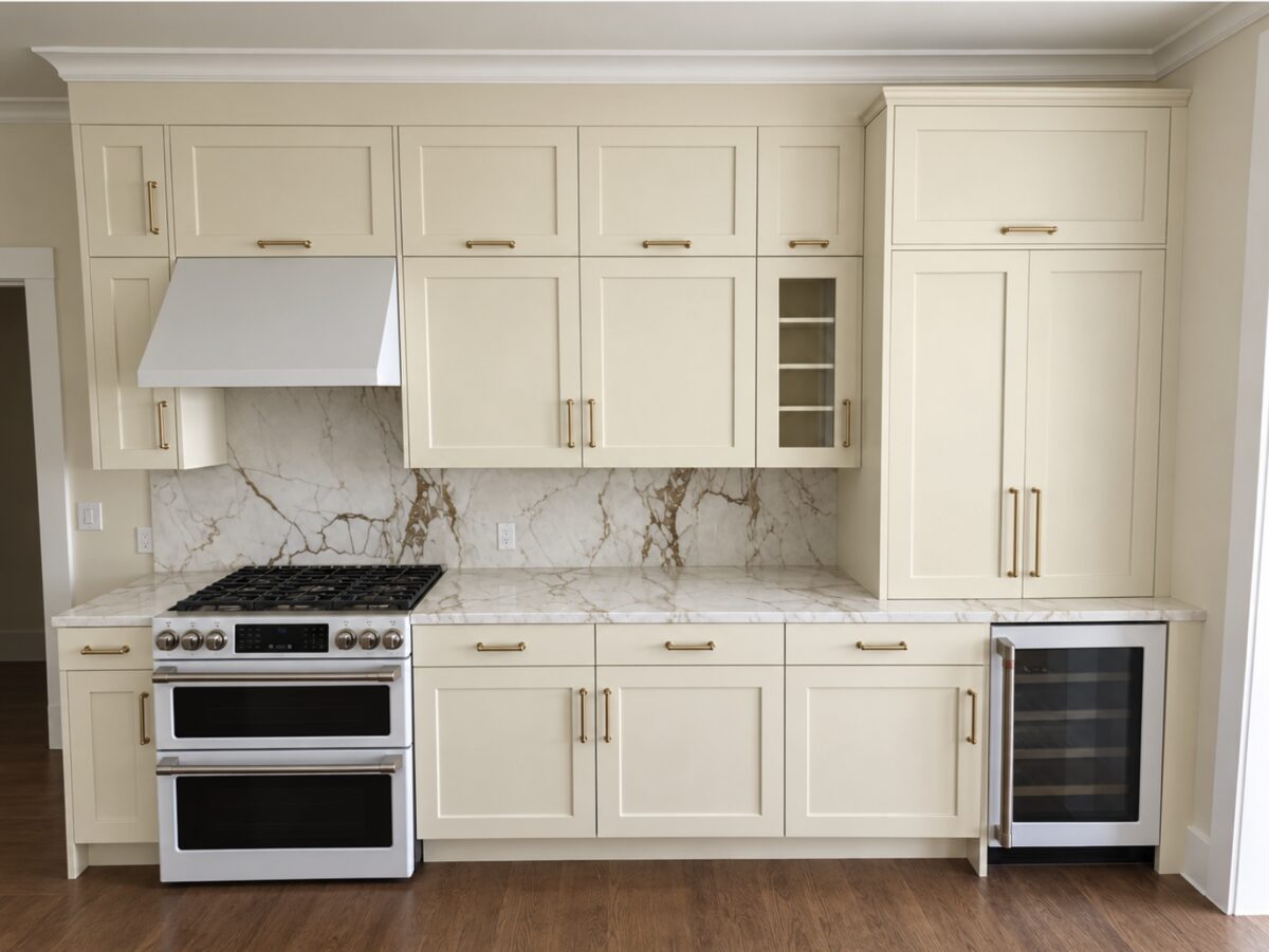 Painted cream shaker kitchen cabinets with brass pulls and marble backsplash — DodiHome, San Francisco