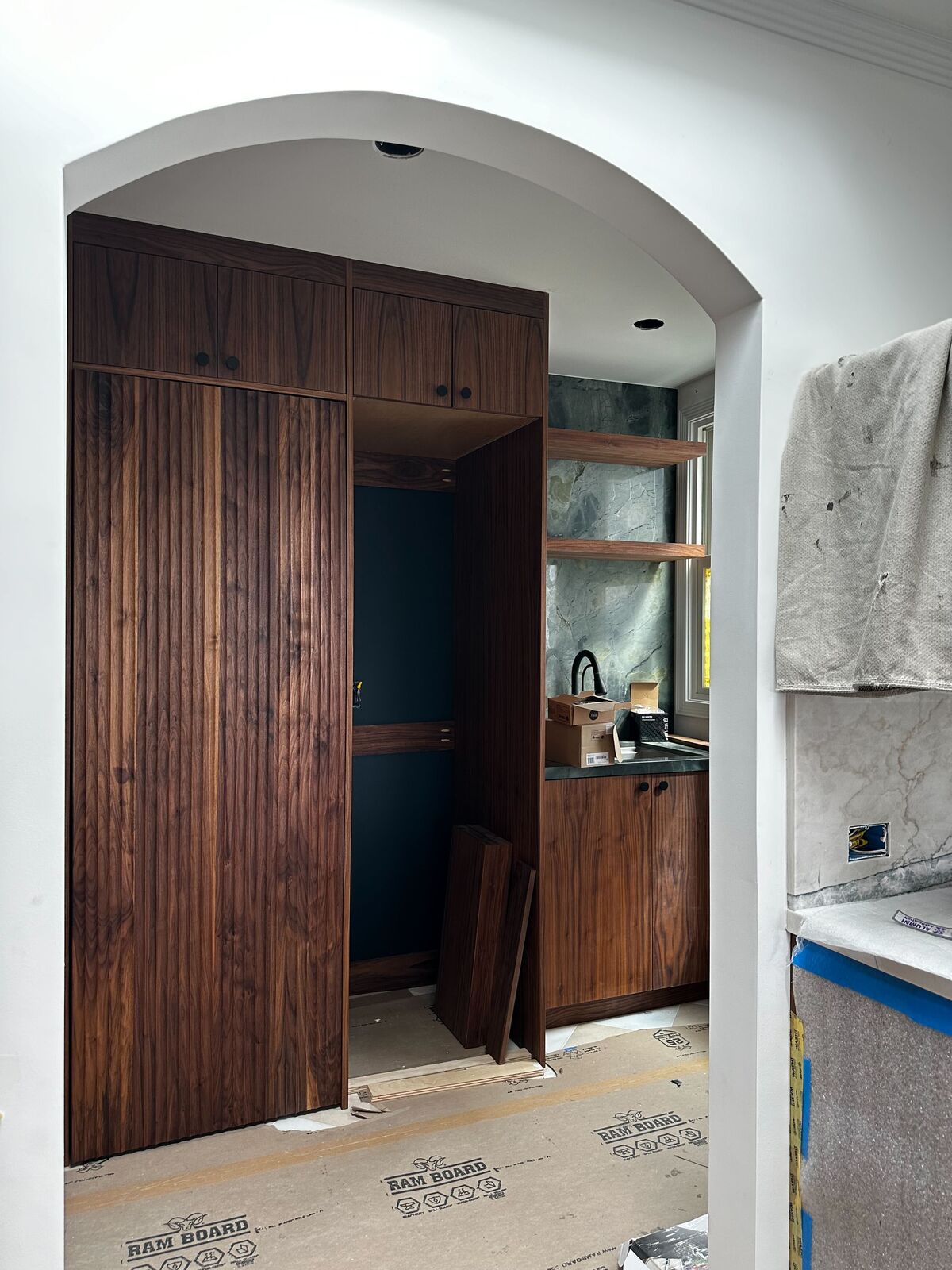 Walnut pocket doors with fluted detail — DodiHome custom pantry project